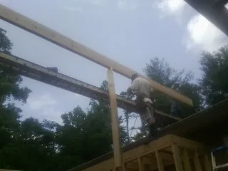 Carpenter setting a ridge beam over a new addition frame — Ice Dam Removal by Roofing Brothers in Tower City