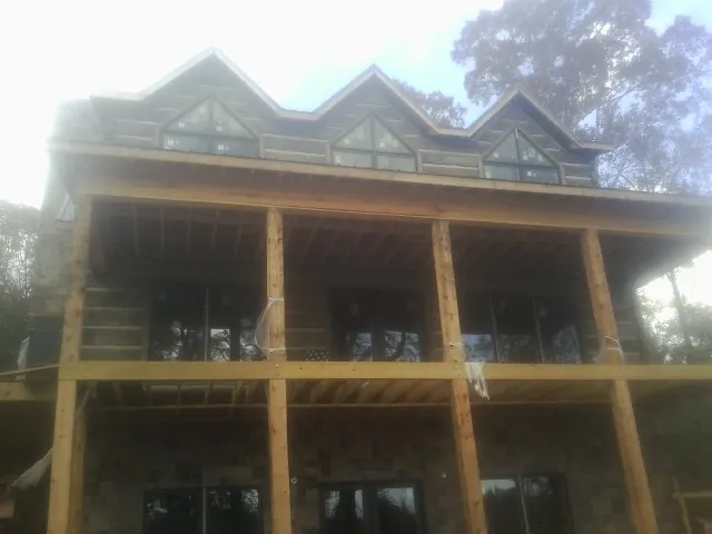 Dormers and porch framing on a large log home under construction — Roof Coating work by our crew in Tower City
