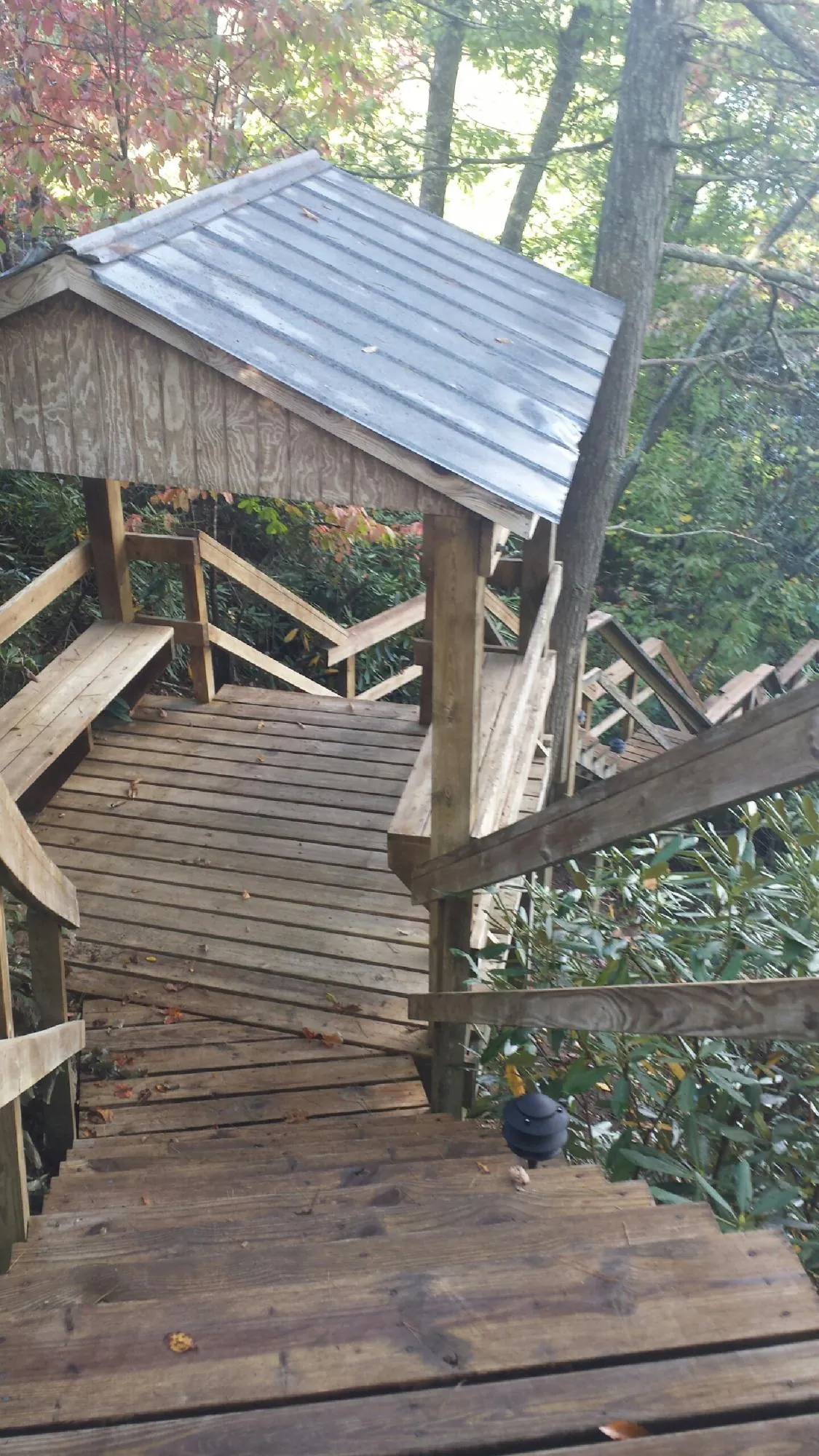 Metal roofed shelter over wooden steps on a wooded walkway — Skylight Repair & Installation work by our crew in Tower City